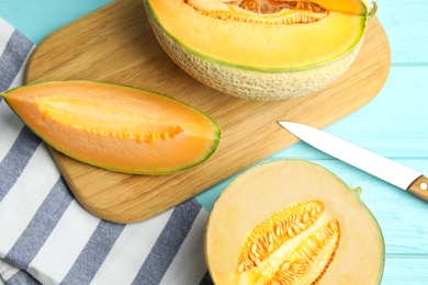 Photo of Tasty fresh melons on light blue wooden table, flat lay