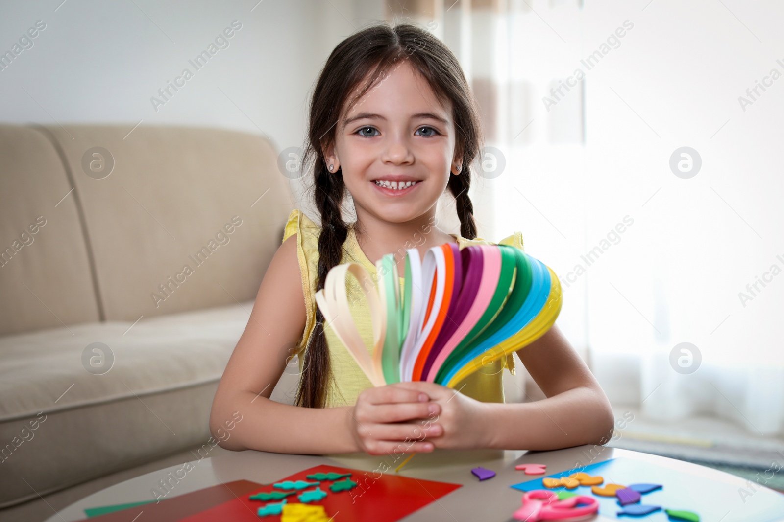 Photo of Little girl quilling at table indoors. Creative hobby