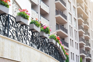 Exterior of building with balconies decorated with beautiful flowers, low angle view