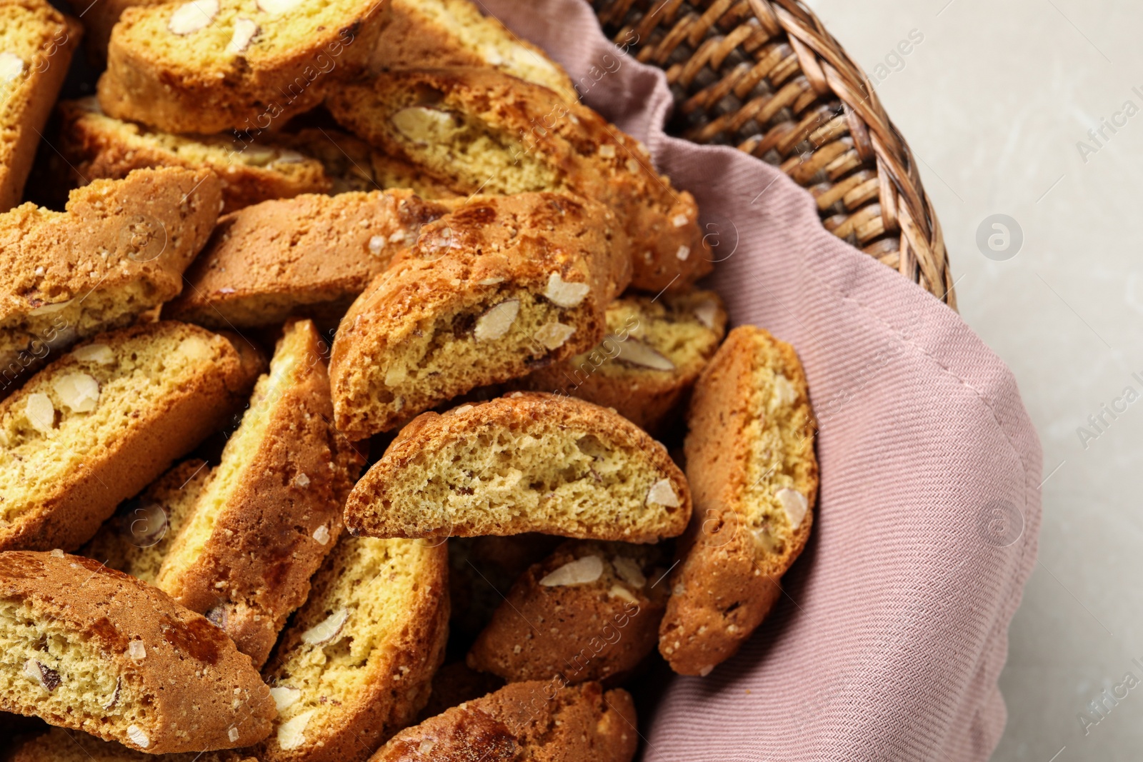 Photo of Traditional Italian almond biscuits (Cantucci) in basket on table, closeup