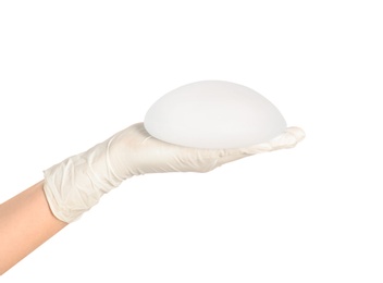 Photo of Doctor holding silicone implant for breast augmentation on white background. Cosmetic surgery