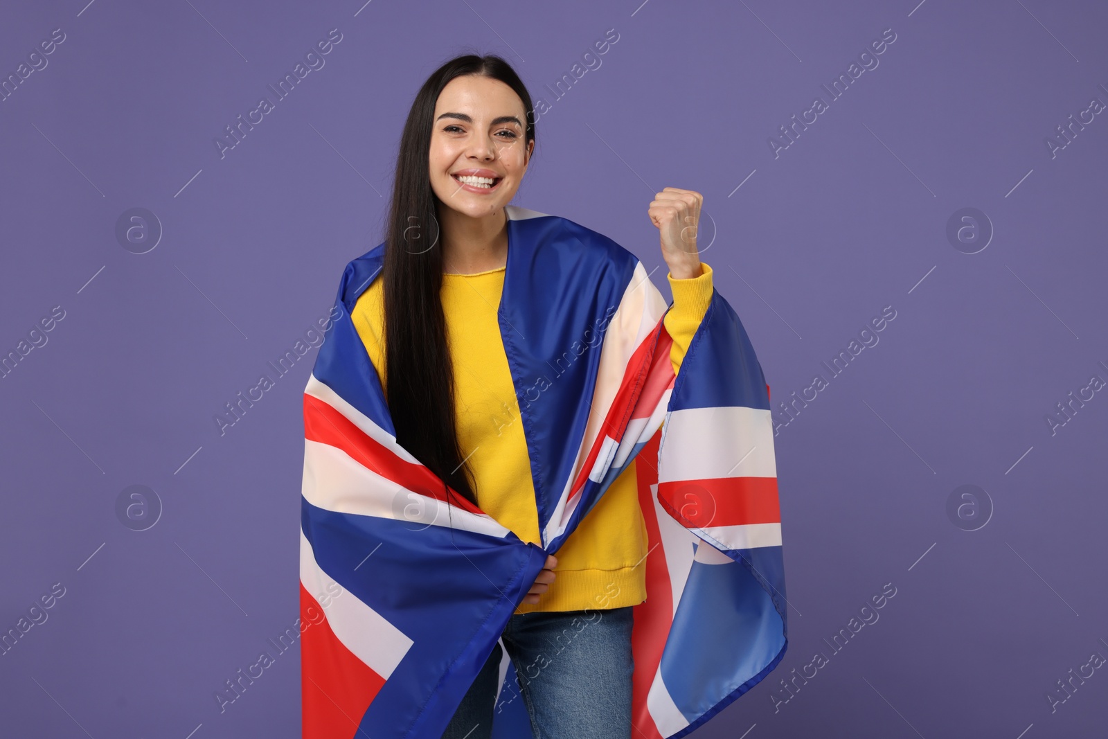 Photo of Happy young woman with flag of United Kingdom on violet background