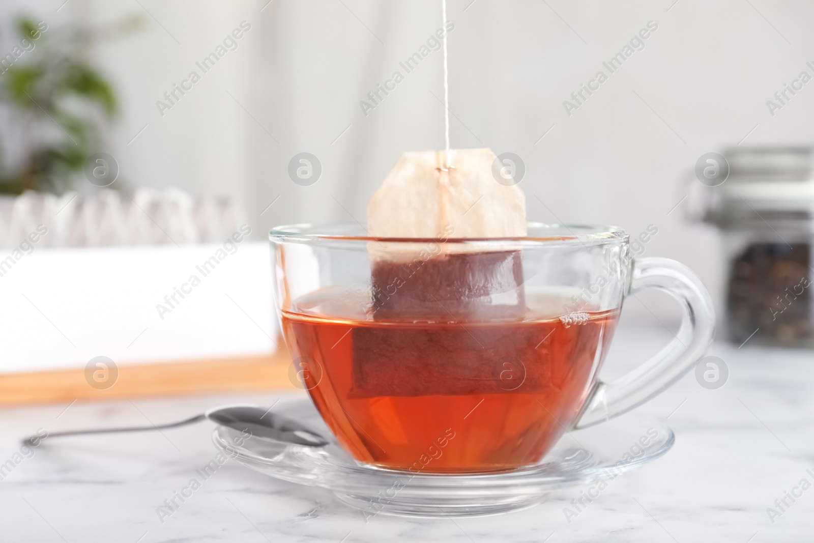 Photo of Brewing tea with bag in cup on table