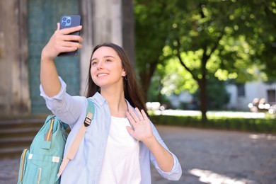 Photo of Beautiful travel blogger with smartphone streaming outdoors