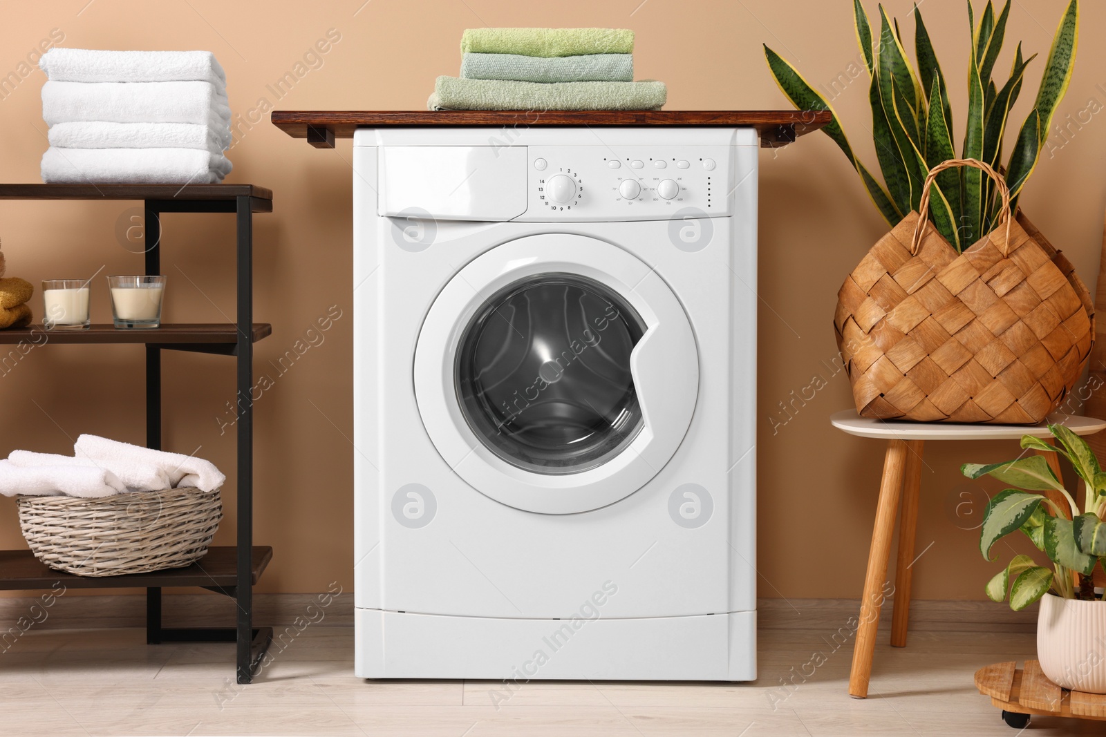 Photo of Stylish laundry room with modern washing machine. Interior design