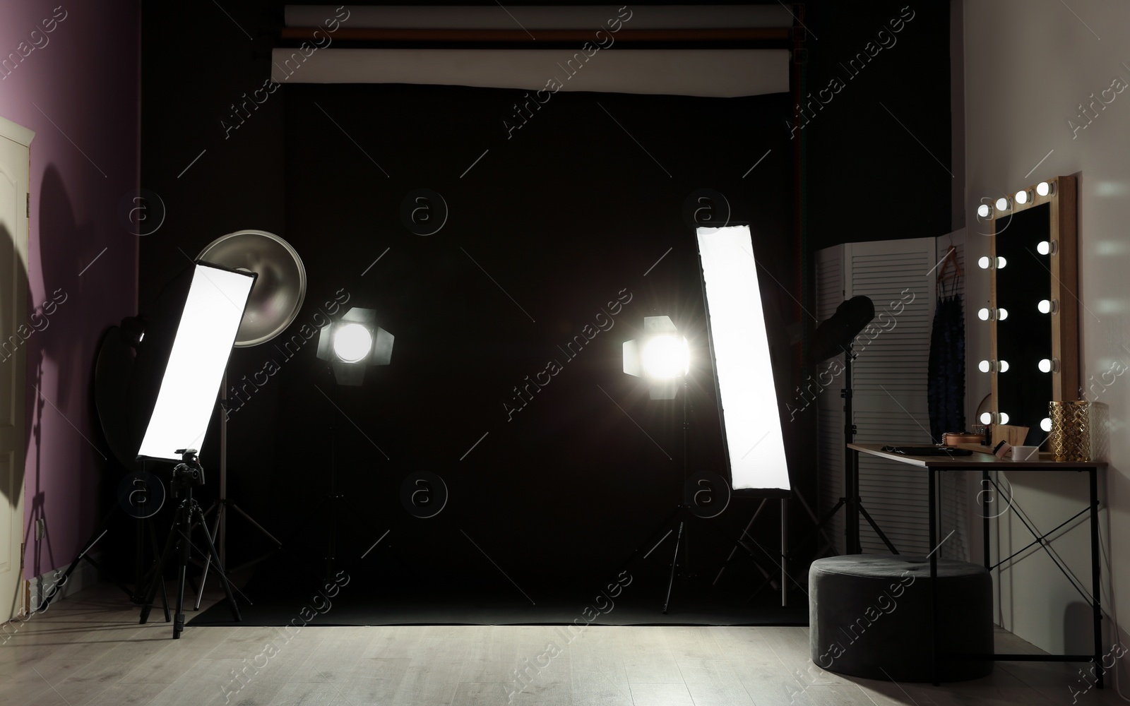 Photo of Interior of modern photo studio with dressing table and professional lighting equipment