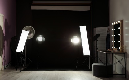 Interior of modern photo studio with dressing table and professional lighting equipment