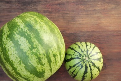 Different delicious ripe watermelons on wooden table, top view