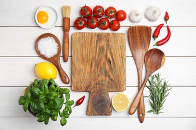 Flat lay composition with cooking utensils and fresh ingredients on white wooden table