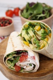 Delicious sandwich wraps with fresh vegetables on wooden board, closeup