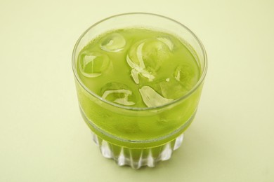 Photo of Glass of delicious iced matcha tea on green background, closeup