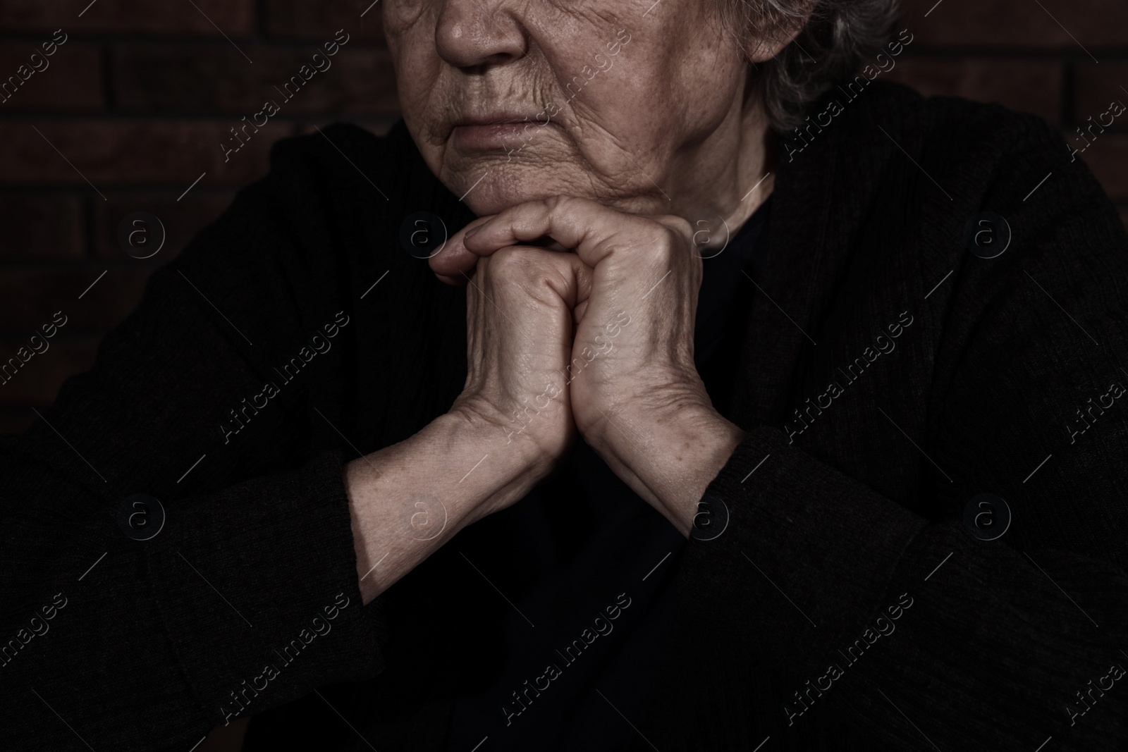 Photo of Poor mature woman on dark background, closeup