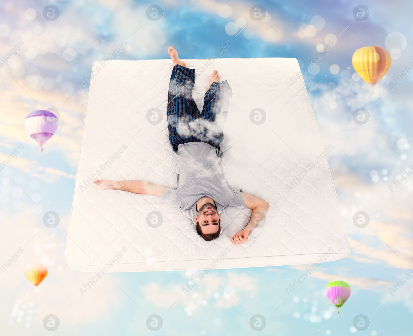 Image of Sweet dreams. Blue cloudy sky with hot air balloons around young man