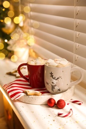 Composition with cup of hot drink on windowsill