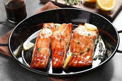 Photo of Dish with tasty cooked salmon on table, closeup