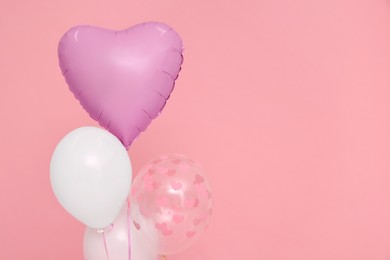 Photo of Bunch of heart and round shaped balloons on pink background, space for text. Birthday party