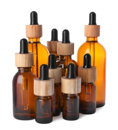 Different bottles of essential oil on white background