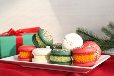 Photo of Beautifully decorated Christmas macarons on red fabric