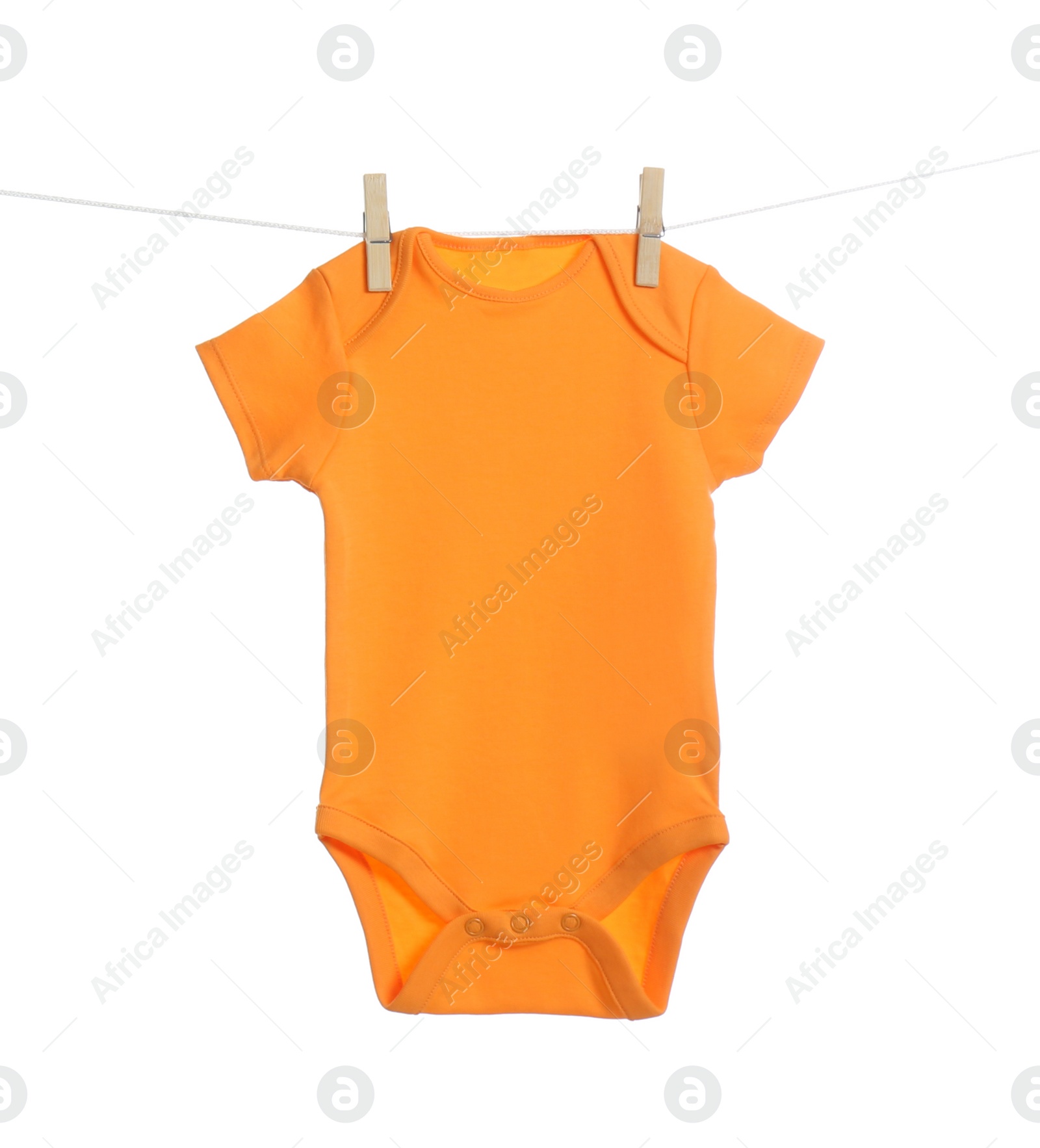 Photo of Baby onesie hanging on clothes line against white background. Laundry day