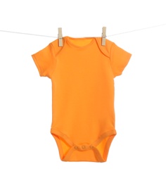 Baby onesie hanging on clothes line against white background. Laundry day