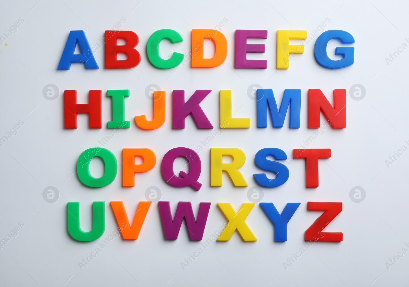 Photo of Plastic magnetic letters isolated on white, top view. Alphabetical order