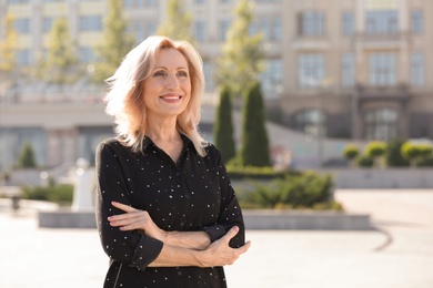 Portrait of happy mature woman on city street