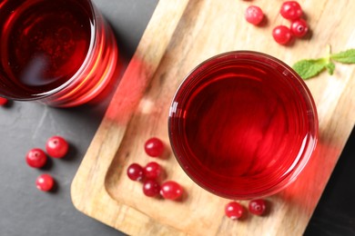 Photo of Tasty refreshing cranberry juice and fresh berries on grey table, top view