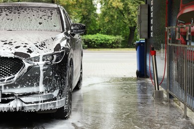 Auto with cleaning foam at car wash