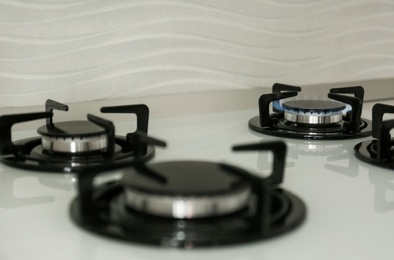 Photo of Gas burners with blue flame on modern stove