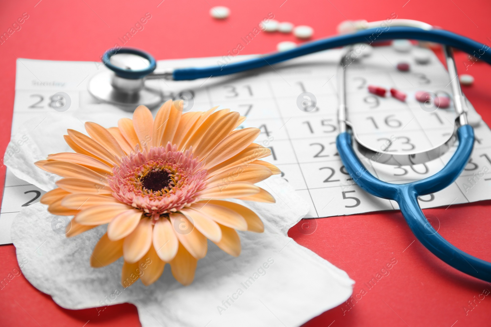 Photo of Composition with stethoscope, calendar and menstrual pad on color background. Gynecological checkup