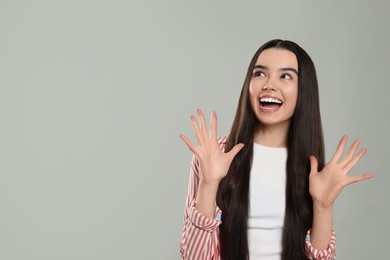 Portrait of emotional teenage girl on light grey background. Space for text