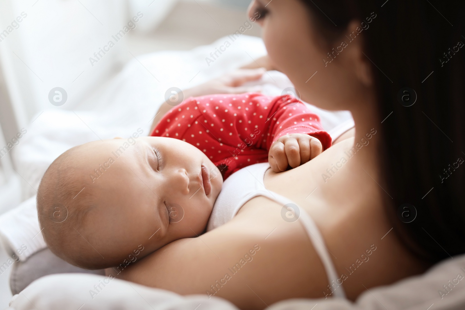 Photo of Young mother with her cute baby girl at home