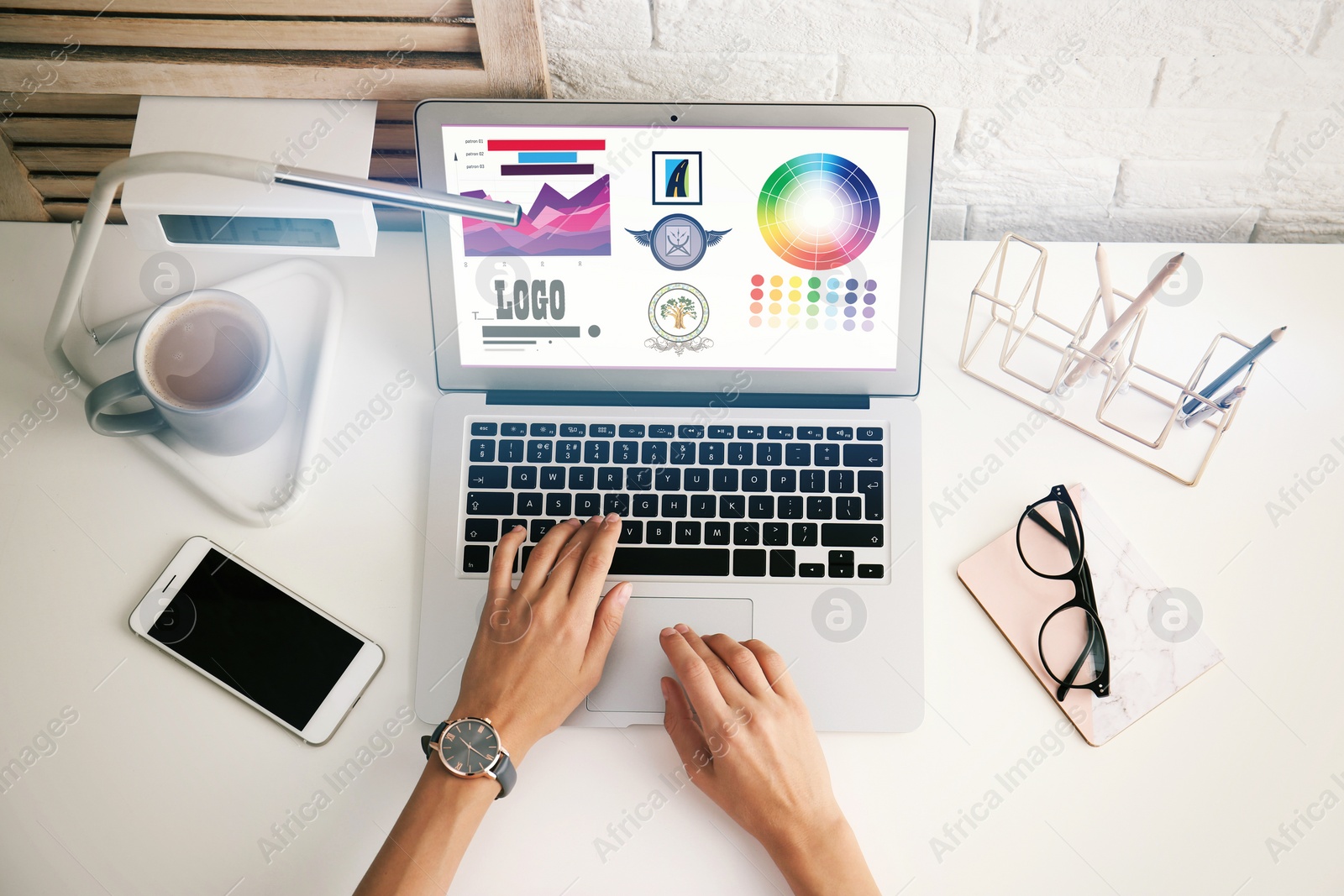 Image of Top view of professional female designer working with laptop at desk, closeup 