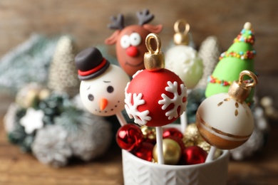 Delicious Christmas themed cake pops on blurred background, closeup