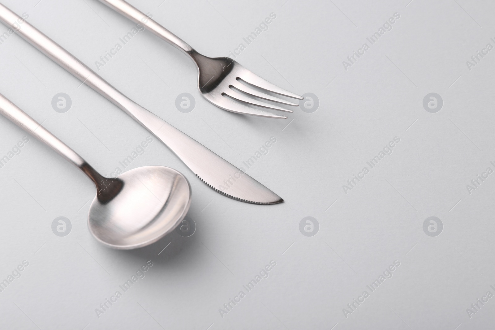 Photo of Stylish cutlery set on grey table, closeup. Space for text