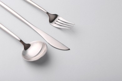 Stylish cutlery set on grey table, closeup. Space for text