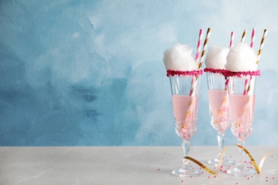 Photo of Cocktail with cotton candy in glasses on table. Space for text