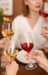 Photo of Young people with glasses of delicious wine at table