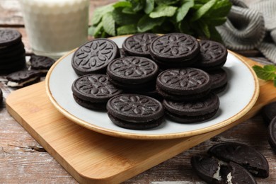 Photo of Plate with tasty sandwich cookies on wooden table, closeup