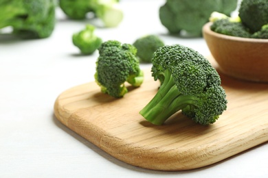 Photo of Composition with fresh broccoli on light table, closeup. Space for text