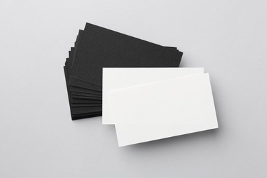 Photo of Blank black and white business cards on light background, top view. Mockup for design