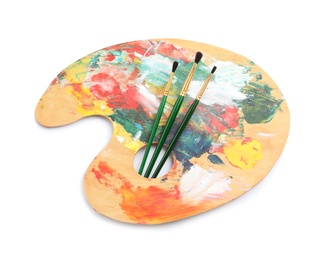 Photo of Wooden palette with brushes on white background, top view. Painting equipment for children