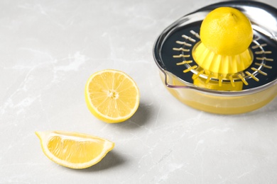 Photo of Slices of lemon and juicer on gray table