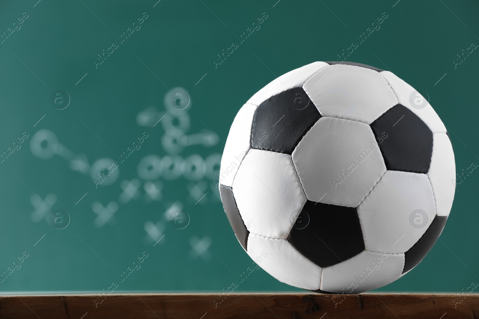 Photo of Football ball against blurred game scheme. Space for text