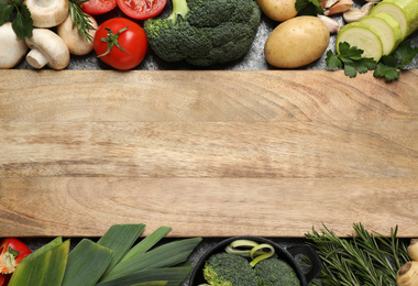 Photo of Fresh products and wooden board with space for text, flat lay. Healthy cooking
