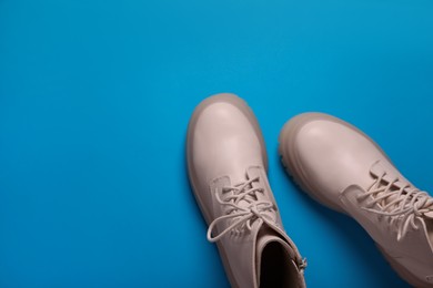 Pair of stylish leather shoes on light blue background, flat lay. Space for text