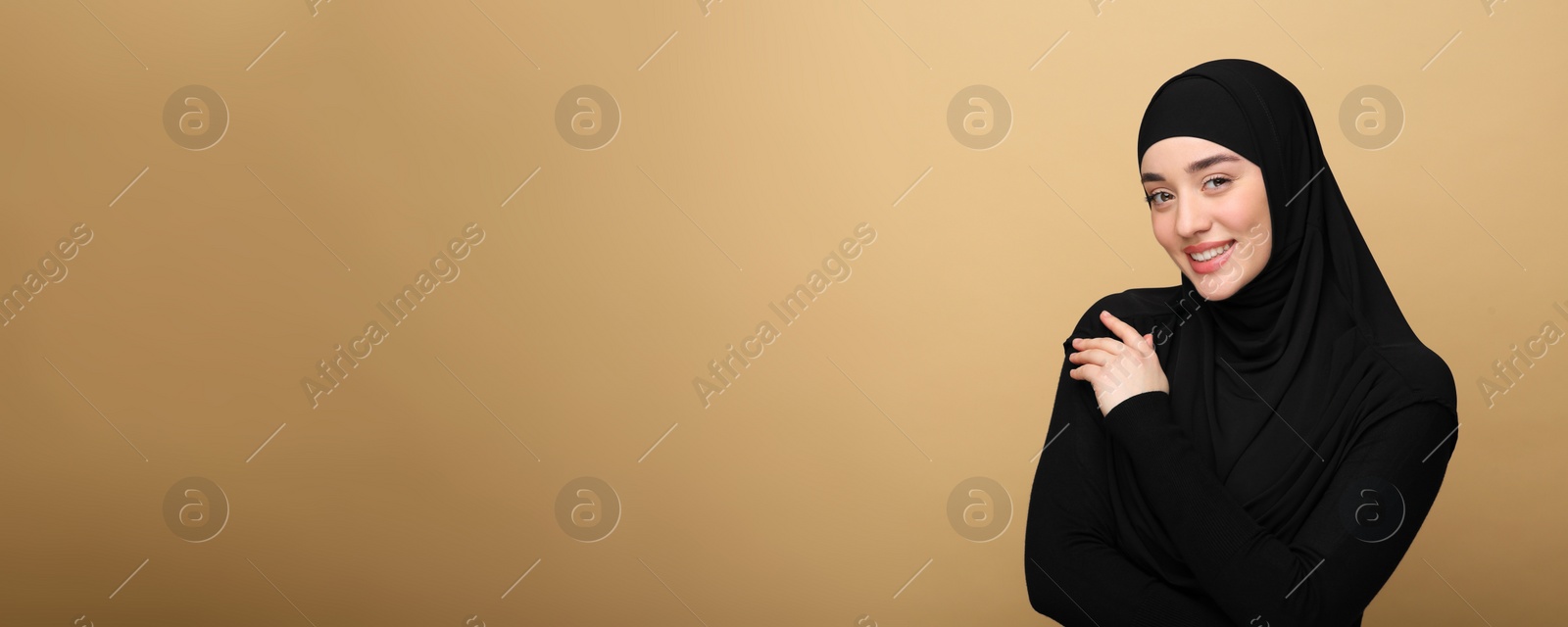 Image of Portrait of Muslim woman in hijab on beige background, space for text. Banner design