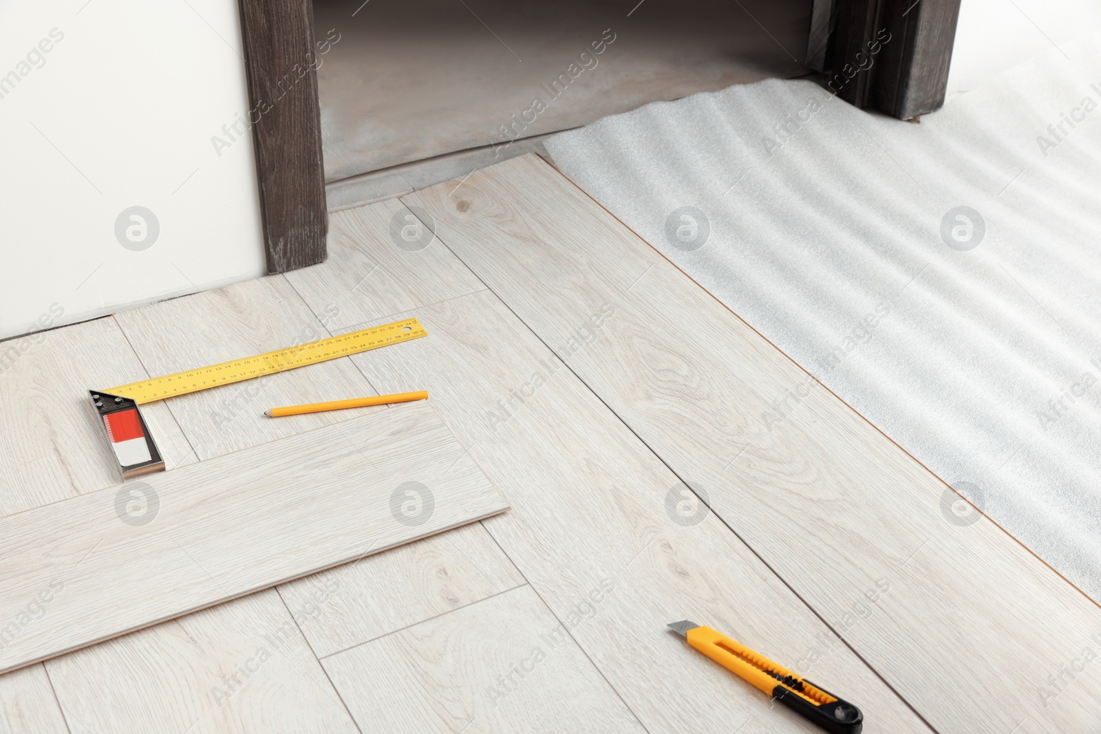 Photo of Repair tools and parquet planks on floor in room