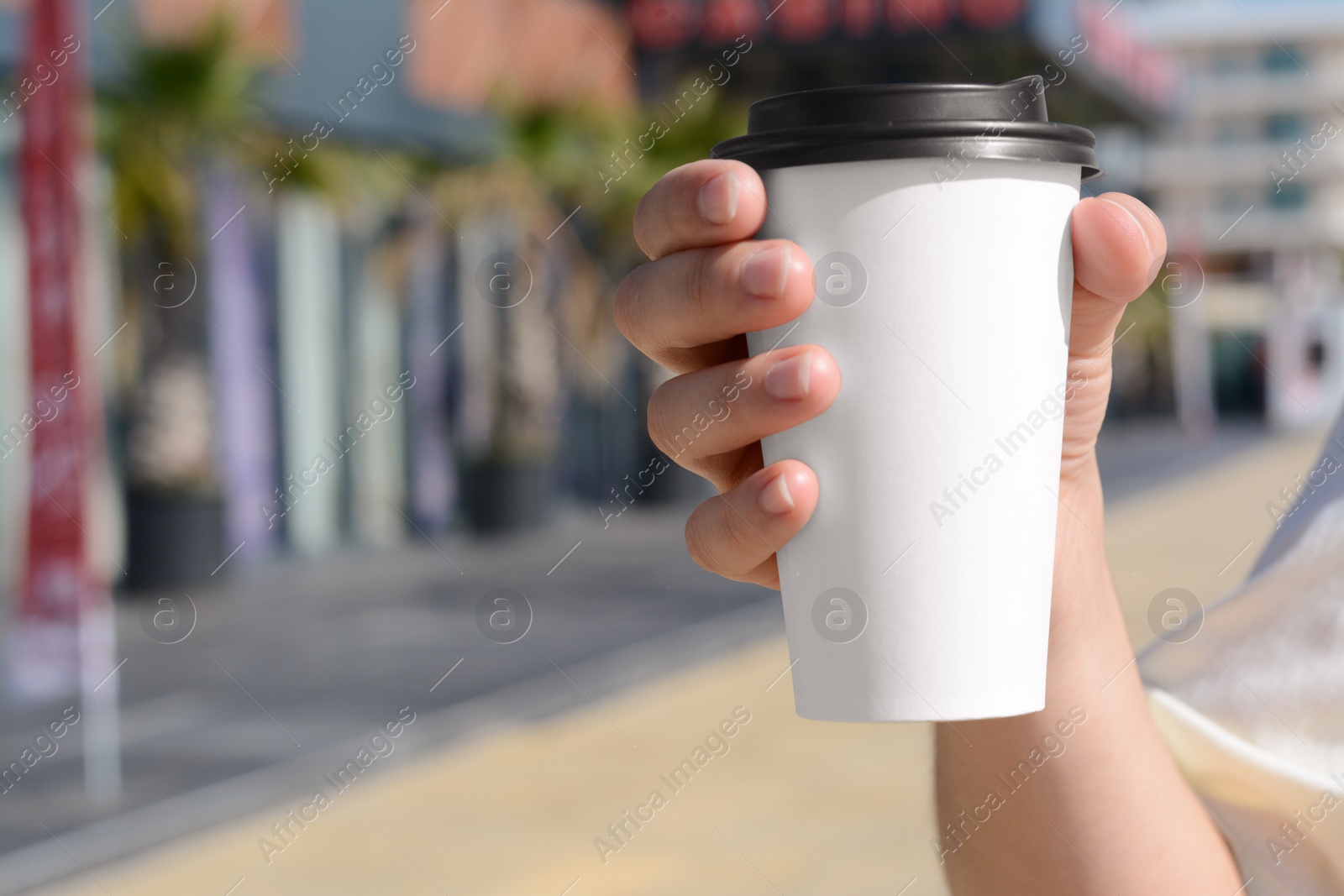 Photo of Woman holding takeaway coffee cup outdoors, closeup. Space for text