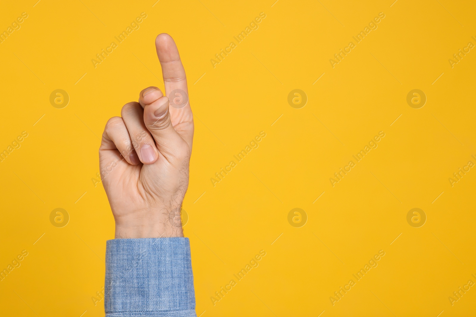 Photo of Man snapping fingers on yellow background, closeup of hand. Space for text